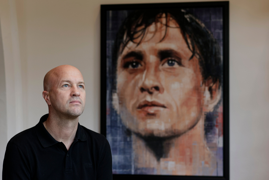 Jordi Cruyff junto a la imagen de su padre Johan Cruyff en la sede de Johan Cruyff institute en Barcelona.
